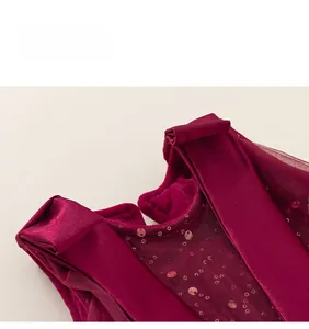 Dettaglio del tessuto in velluto e tulle con paillettes su un abito da festa rosso scuro
