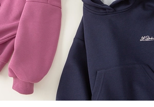 Detail view of purple and navy blue children's hoodies with soft cotton fleece and pockets