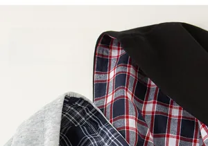 Detail of kids hooded jacket featuring plaid lining and soft knitted fabric texture
