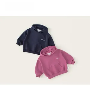 Detail of navy and rose pink kids hoodies featuring white embroidery and kangaroo pockets