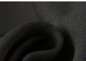 Close-up of black knitted fabric detail showing high-density soft textile texture