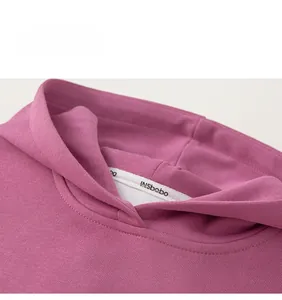 Close-up of neckline detail on kids purple cotton hoodie with brand logo ribbon