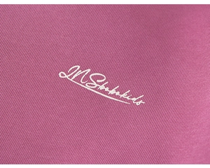 Close-up of kids hooded sweatshirt with white embroidered letter detailing on knit fabric