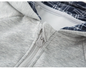 Close-up of gray knit hoodie with blue plaid lining and high-quality zipper detail