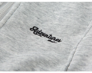 Detail of light grey kids hoodie featuring premium zipper and Adventures embroidery