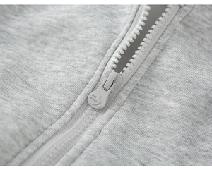 Close-up of light gray knit fabric and injection molded zipper with engraved detail