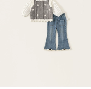 Detail view of girls' grey floral knit vest, ruffled shirt and flared jeans outfit