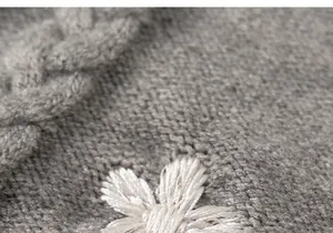 Close-up of light grey knit fabric with 3D white flower embroidery and texture