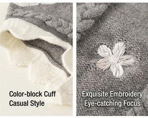 Detail of grey knit sweater showing white contrast wavy cuffs and floral embroidery