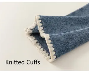 Detail of blue denim trousers featuring unique white knitted scalloped hem design