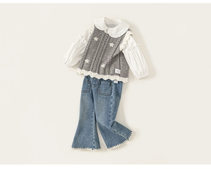 Detail view of girls' white ruffle collar shirt with floral knit vest and denim flare pants