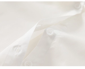 Detailed close-up of white cotton shirt fabric texture and neat four-hole button stitching