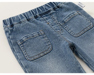 Detail view of children's blue denim bell-bottom pants with elastic waist and back pockets