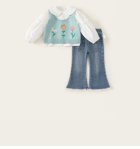 Détail à plat de l'ensemble chemise à volants, gilet en tricot fleuri et jean évasé