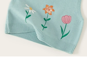 Vue détaillée du gilet tricoté vert menthe avec broderies de fleurs colorées