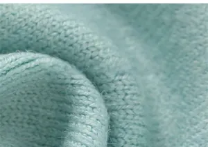 Vue macro de la texture d'un tricot vert menthe doux avec fibres fines et tissage