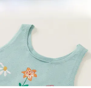 Détail du gilet tricoté vert menthe avec broderie florale fine et encolure ronde classique