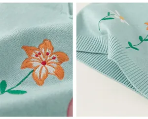 Détails de broderie de marguerites et ourlet côtelé sur un gilet en maille vert menthe
