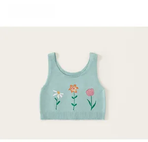 Détail du gilet en tricot bleu clair avec broderie florale et ourlet côtelé