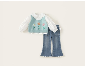 Détails de broderie florale sur gilet en tricot bleu et chemisier blanc pour filles