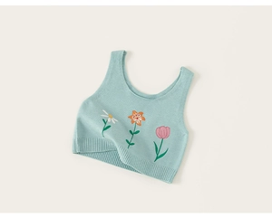 Détail du gilet en tricot vert menthe avec broderies florales et ourlet côtelé