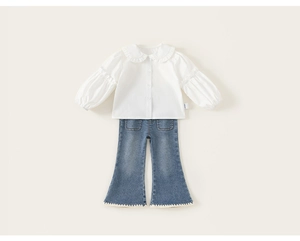 Détail de chemise blanche à volants avec manches bouffantes et jean évasé avec crochet