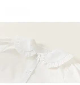 Détail de chemise blanche avec col Claudine à volants et boutons ronds blancs