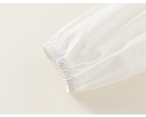 Gros plan des poignets élastiques blancs en tissu délicat pour tenue d'enfant élégante
