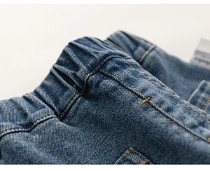 Détail du pantalon en jean évasé pour fille avec taille élastique et coutures précises