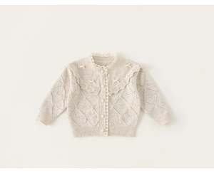Detail van gebreid vest met kant kraag, ruches en strikjes voor kleine meisjes