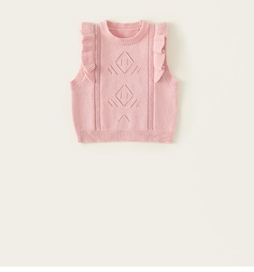 Detail of pink knitted girl's vest with ruffled shoulders and diamond openwork pattern