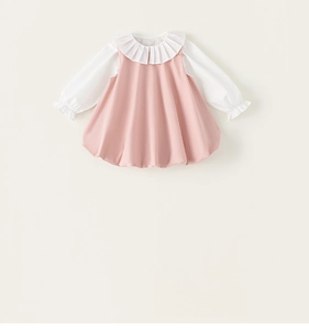 Détail de la robe chasuble rose pour fille avec col à volants blancs et poignets