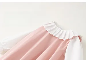 Vue détaillée de la robe rose à volants en coton doux avec manches longues blanches