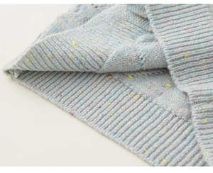 Close-up van gebreid vest voor meisjes met kleurrijk gespikkeld garen en ribtextuur