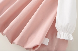 Détail de la robe en coton rose montrant les poignets élastiques à volants doux