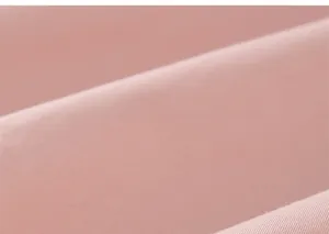 Gros plan sur la texture du tissu rose doux et les détails volantés de l'ensemble fille