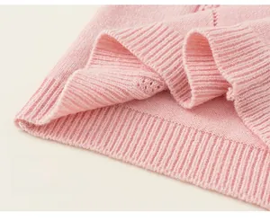 Detail of soft pink knitted vest featuring premium ribbed hem and stretchy texture