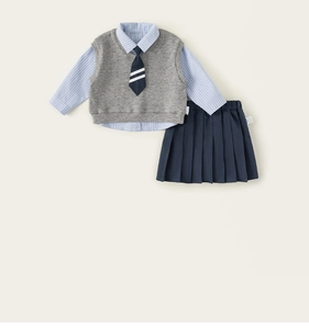 Flat lay of a girls school uniform set featuring a blue shirt, grey vest, and pleated skirt