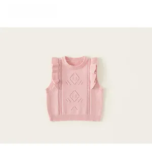Close-up of pink knitted vest featuring hollow diamond patterns and ruffled shoulders