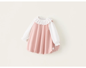 Détail de robe rose et blanche pour fille avec col à volants et poignets élastiques