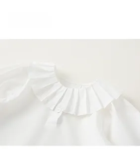 Gros plan d'un col à volants plissés pour chemisier blanc de fille avec bouton