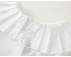 Détail du chemisier blanc en coton avec col Peter Pan à volants et boutons ronds délicats