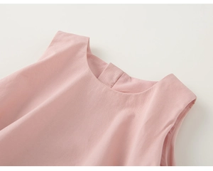Détail de la robe en coton rose montrant le col rond et la fermeture boutonnée au dos