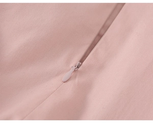 Détail de robe rose à volants montrant une fermeture éclair invisible et tissu sergé