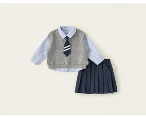 Flat lay of girl's school uniform set with striped shirt, knit vest and pleated skirt