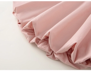 Gros plan détaillé sur l'ourlet à volants et le tissu en coton rose de l'ensemble fille
