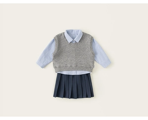 Flat lay of girls' school uniform set featuring striped shirt, vest and pleated skirt
