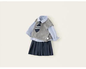 Detailed flat lay of girl's preppy school uniform set with vest, shirt, and pleated skirt