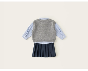 Detailed flat lay of children's preppy set with striped shirt, vest and pleated skirt
