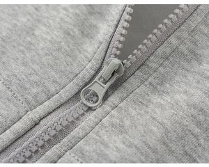 Detailed macro view of a grey heather hoodie with a resin zipper and metal slider